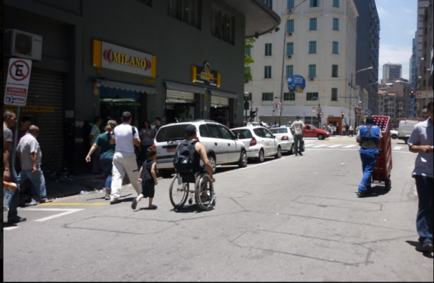 Cadeirante se desloca pela rua por falta de calçada.